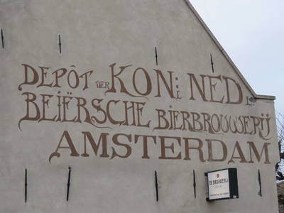 838852 Afbeelding van de geschilderde muurreclame 'Depôt Kon. Ned. Beiersche Bierbrouwerij Amsterdam', op de zijgevel ...